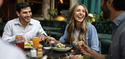 Friends laughing together over a meal at a restaurant